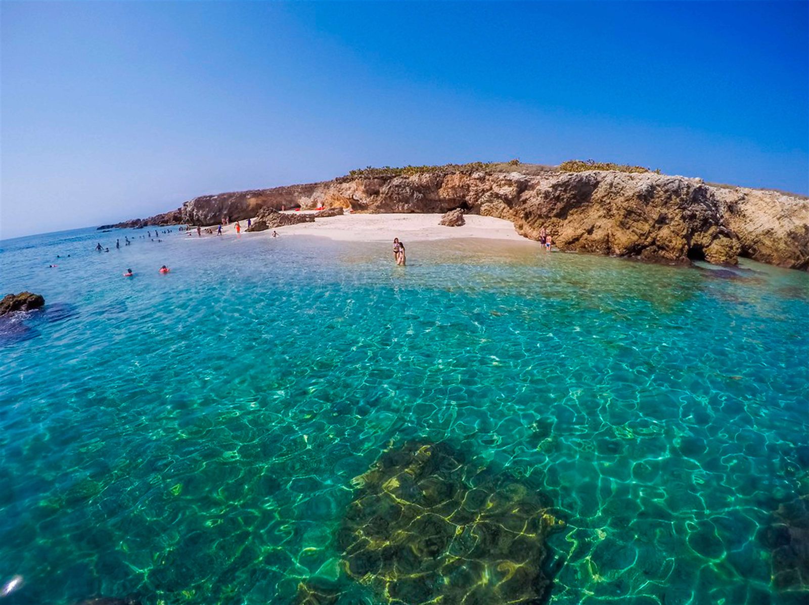 Turistas disfrutando de la arena y el agua turquesa en Playa Nopalera, Islas Marietas