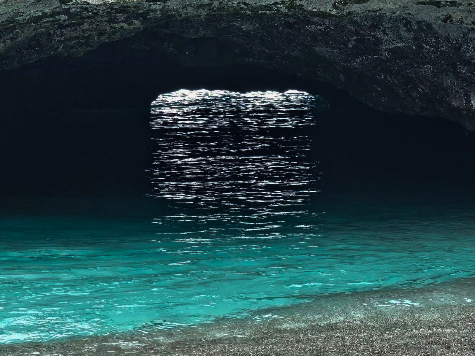 Túnel de entrada a la Playa Escondida visto desde dentro, con el agua turquesa iluminada por el sol